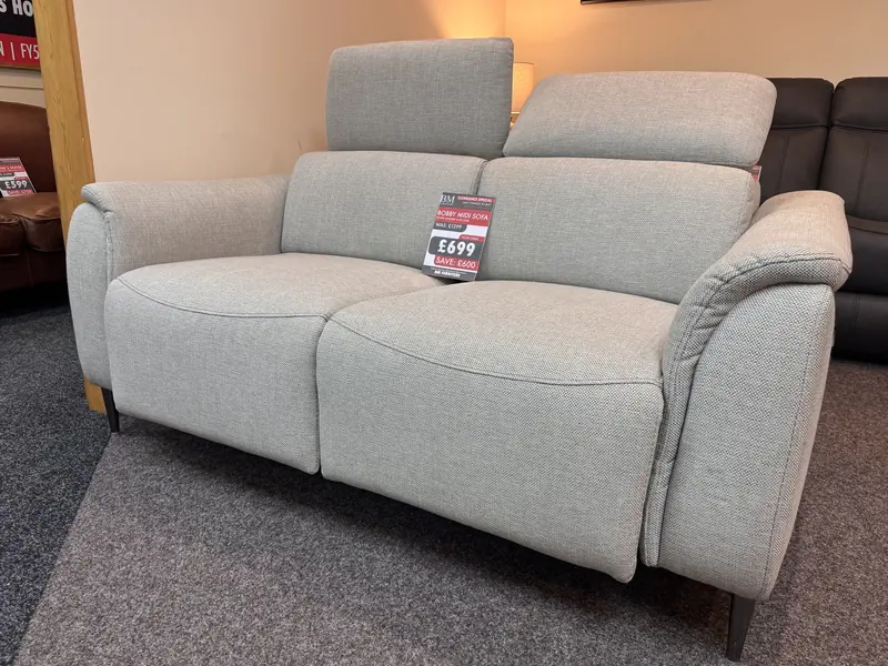 Light grey woven fabric sofa with two adjustable headrests, with its clearance ticket, in our Blackpool showroom