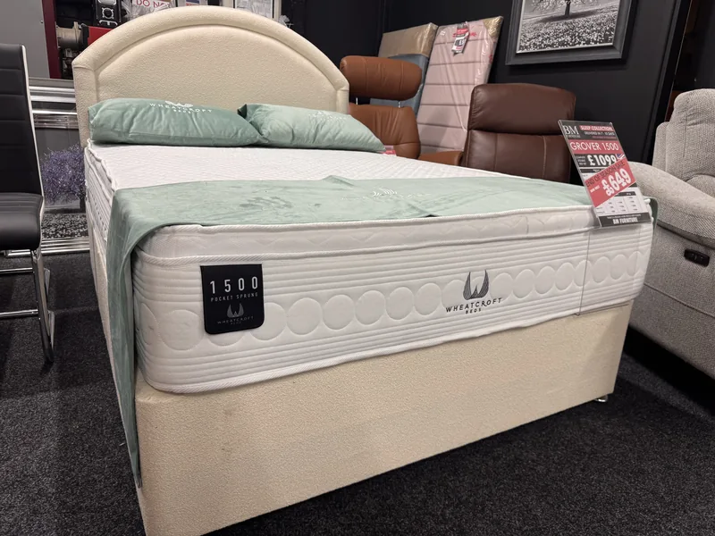 Double divan bed with a cream headboard and pocket sprung mattress, with its price ticket, in our Blackpool showroom