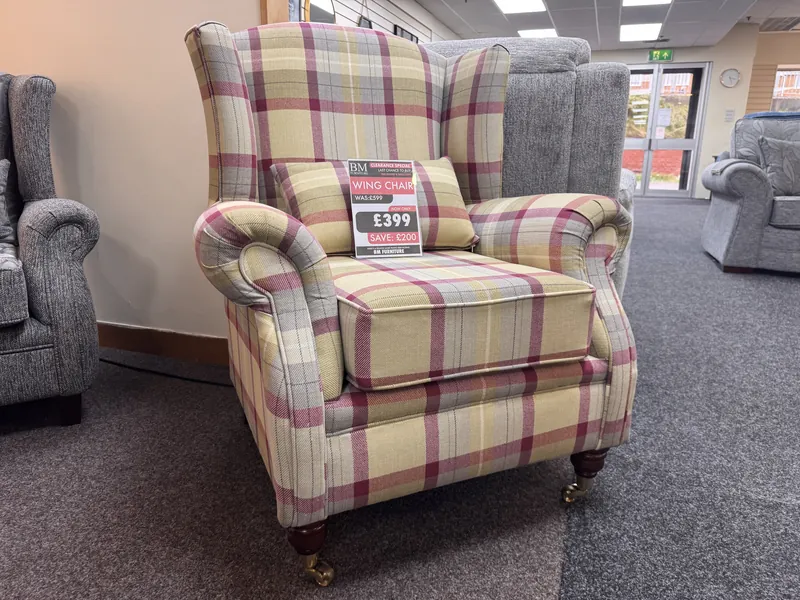 Wing chair in yellow and raspberry check fabric on castor feet, with its clearance ticket, in our Blackpool showroom